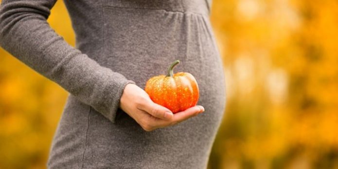 Schwangere Frau mit kleinem Kürbis