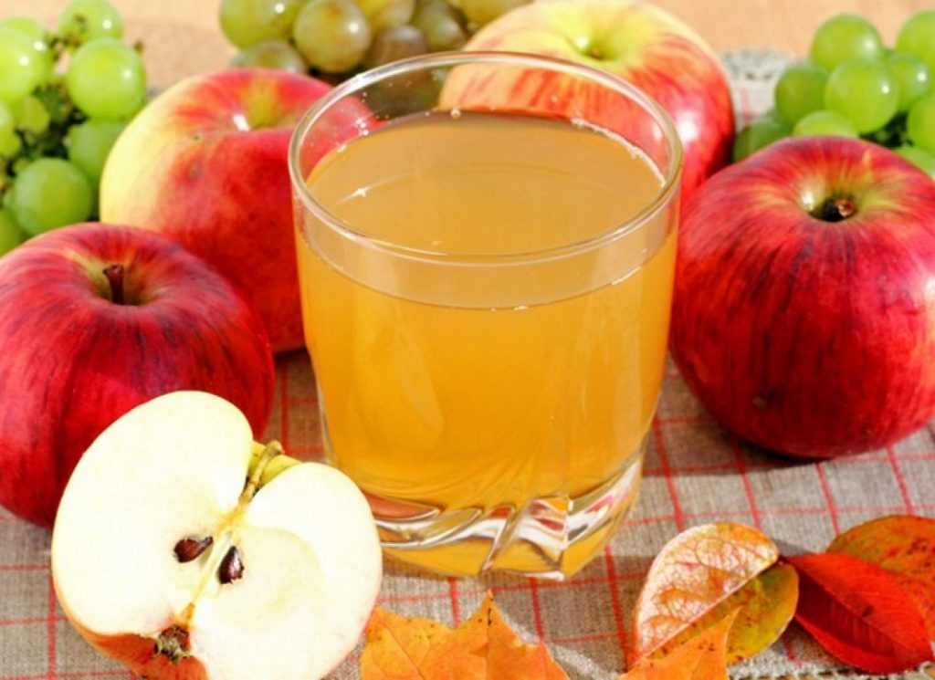 Jus de pomme dans un verre en verre et pommes